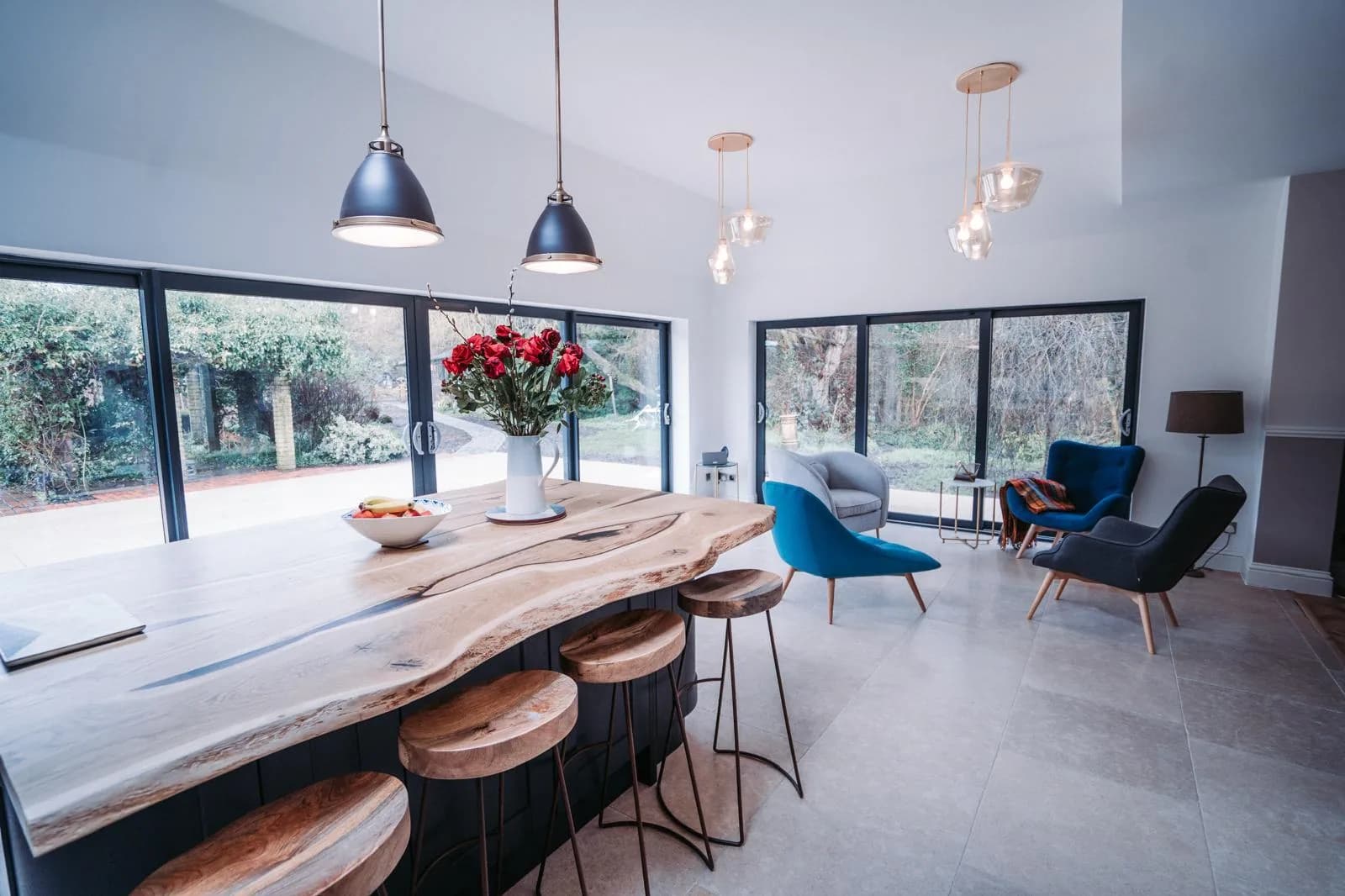 Light-filled open-plan interior with a timber kitchen island, pendant lighting and garden-facing glazing